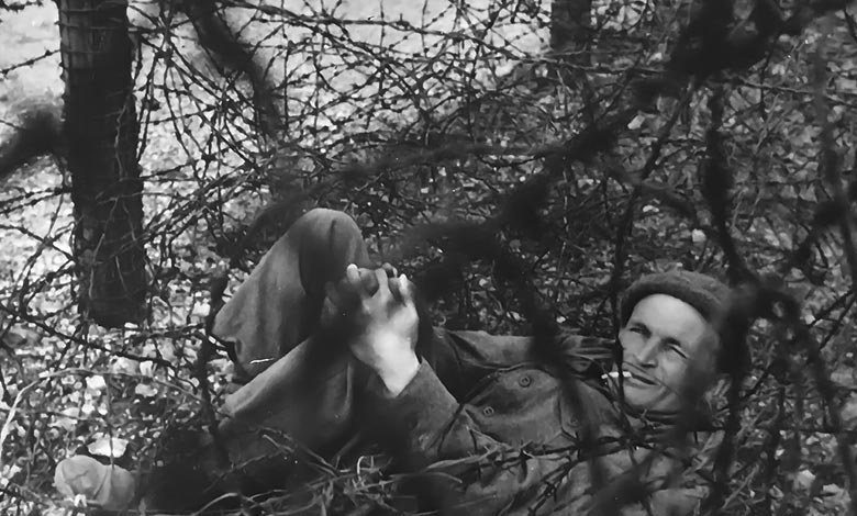 Charles Upham became entangled in a barbed-wire fence trying to escape from a camp. A guard pointed a pistol at his head and threatened to shoot him, Upham calmly lit a cigarette.