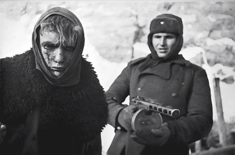 Soviet soldier with a PPSch-41 submachine gun guarding an injured German prisoner of war, 1943