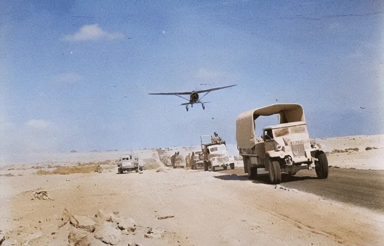 An RAF Lysander flies over a convoy of lorries during the retreat into Egypt, 26 June 1942