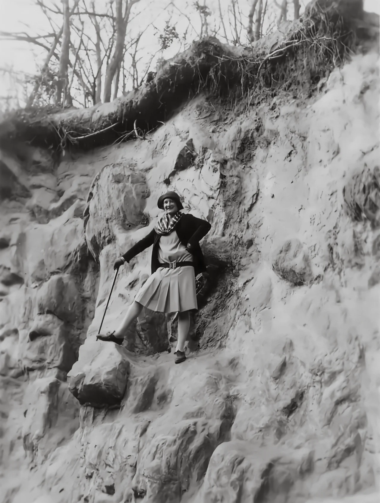 Virginia Hall poses on top of a rock with her walking stick